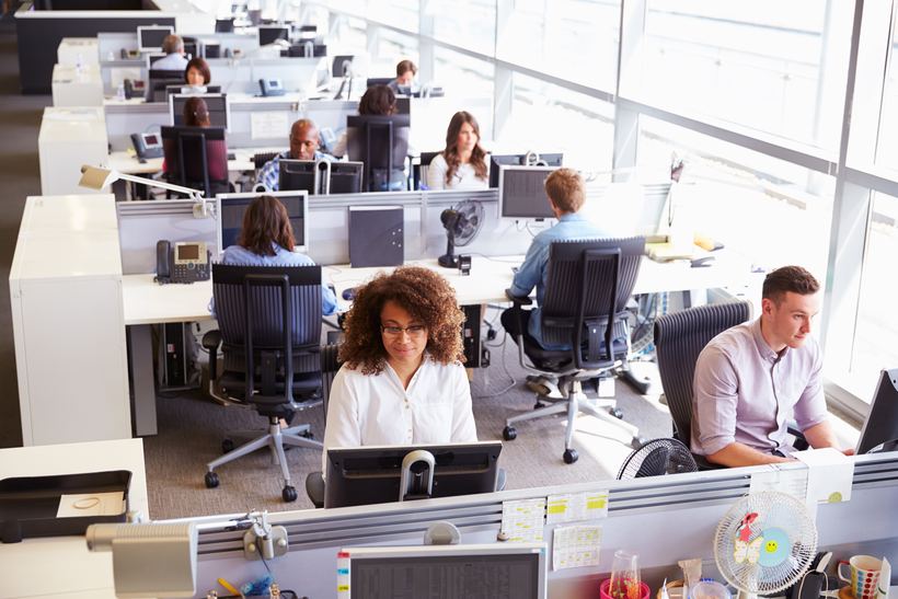 Druk open kantoor met veel werkplekken en achtergrondgeluid